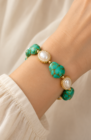 Turquoise bracelet with pearl accents worn on the wrist, showing stone scale, gold-tone details and fit.