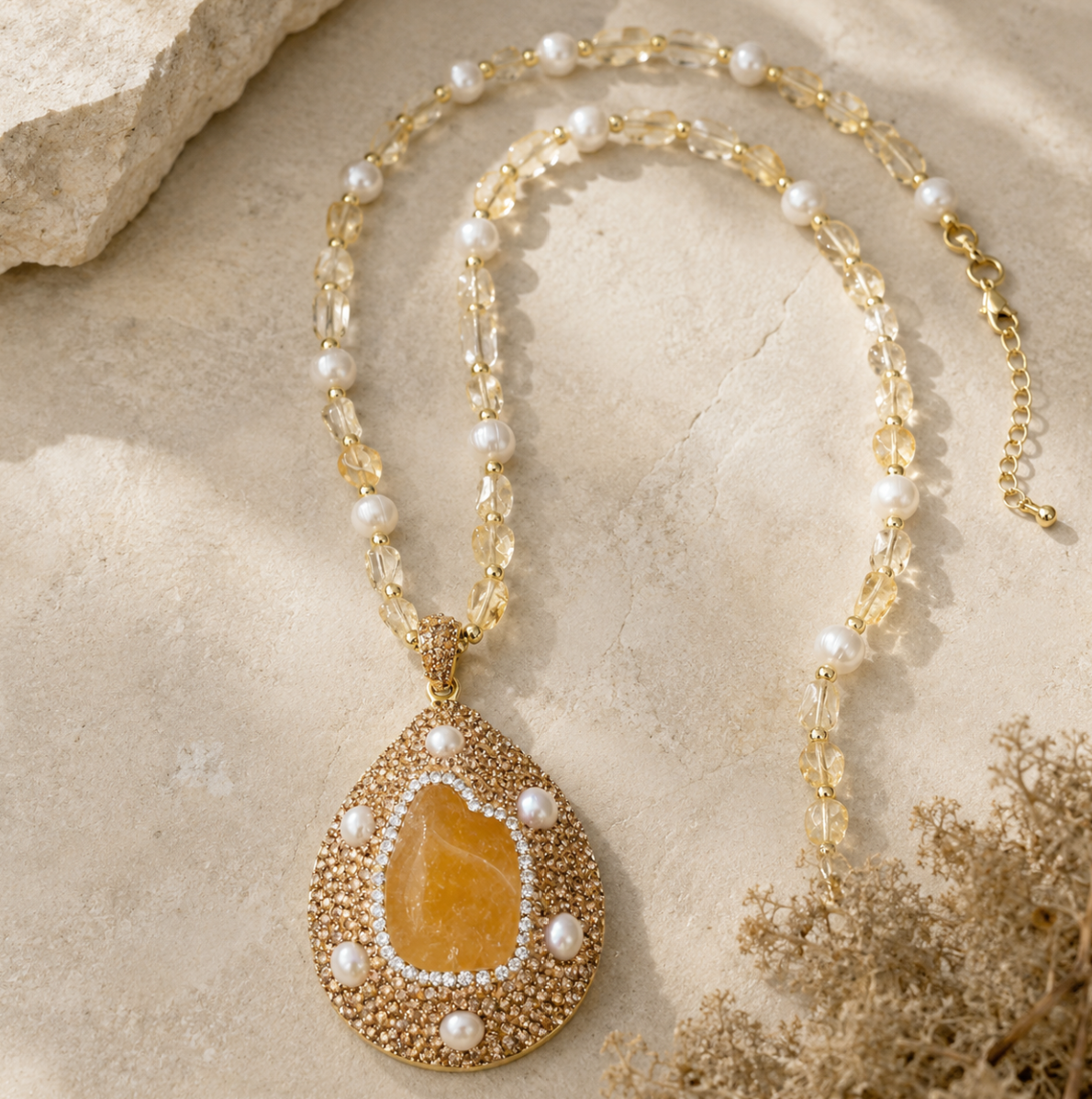 Citrine pendant jewelry styled on the neckline with warm light, soft fabric, and a refined feminine mood.