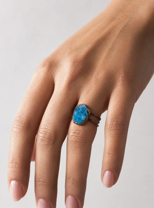 Blue gemstone ring with raw apatite stone, sculptural shape, and calm lake-inspired color.