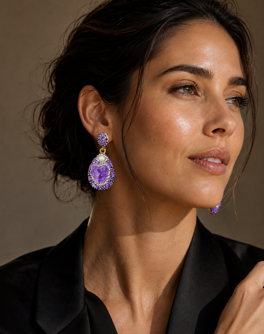 Elegant amethyst stud earrings with dangling purple crystal stones and soft pearl highlights.