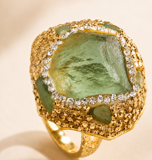 Elegant fluorite gemstone ring featuring a forest green crystal, golden frame, and refined light-catching details.