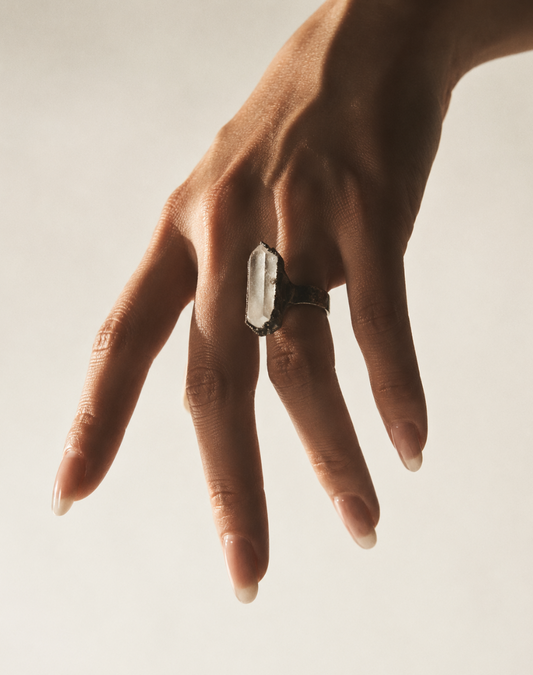 Clear quartz ring featuring a tall crystal point, organic texture, and refined minimalist styling.