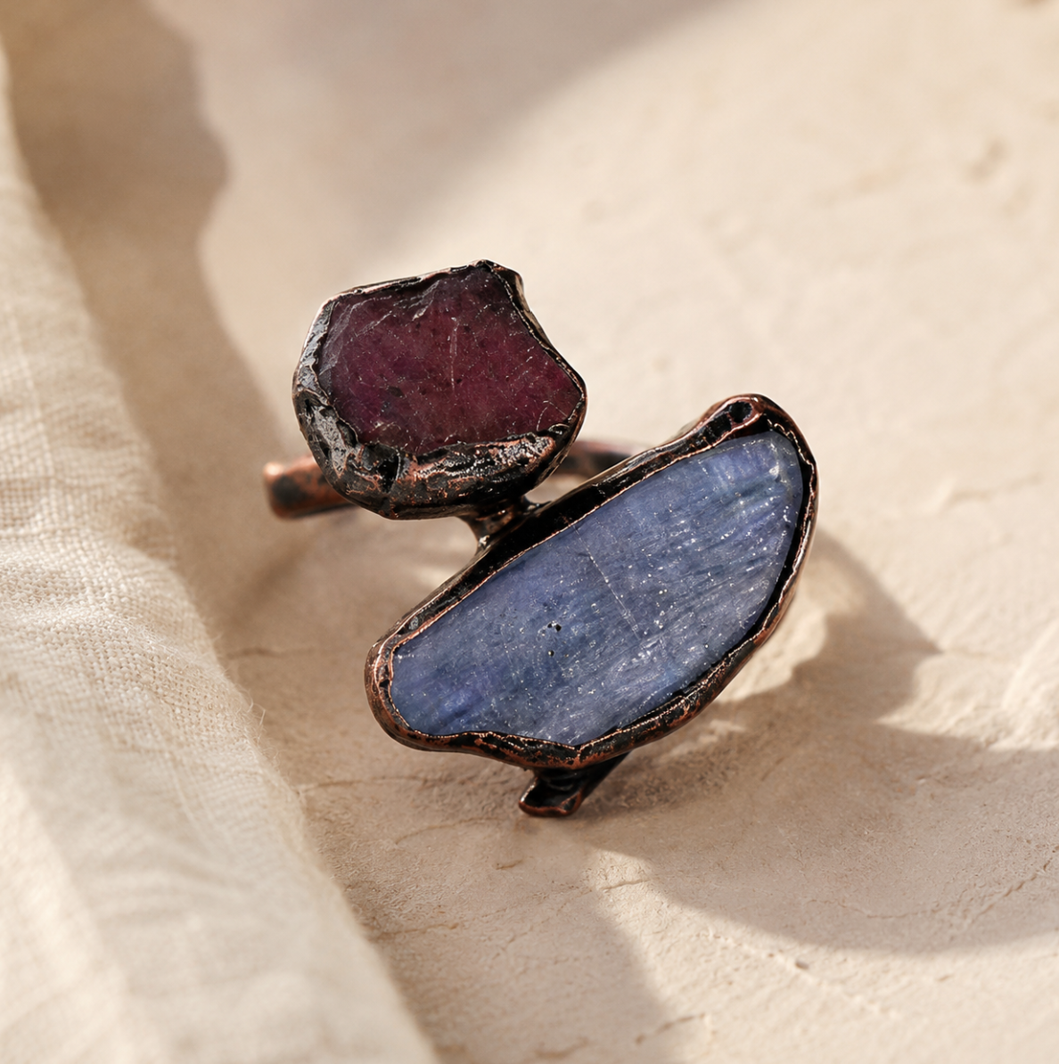 Blue crystal ring with red gemstone contrast, organic texture, and bold handcrafted jewelry mood.