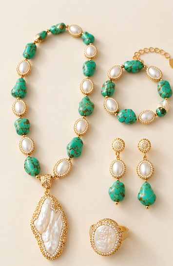Turquoise jewelry set with baroque pearls, necklace, bracelet, drop earrings and ring on a warm off-white background.