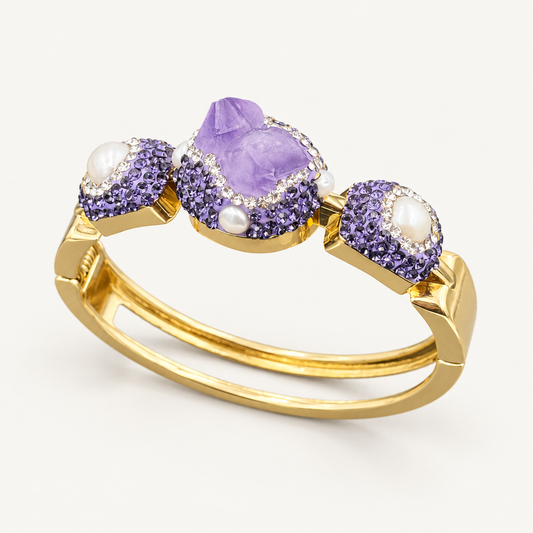 Amethyst bracelet with white accents and a gold-tone double band, shown at an angle on an off-white background.