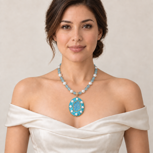 Aquamarine necklace with blue beads, white pearls and an oval pendant worn with an ivory off-shoulder dress.