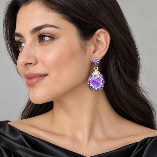 Purple earrings worn with a black satin off-shoulder dress, shown beside the cheek and jawline.
