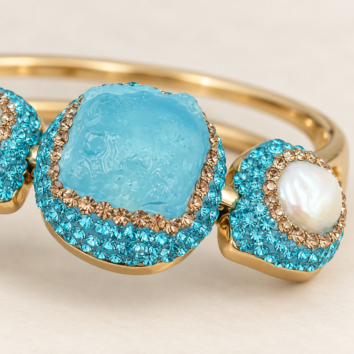 Macro view of the raw turquoise center, champagne-colored Czech crystal edging and a freshwater pearl side accent.