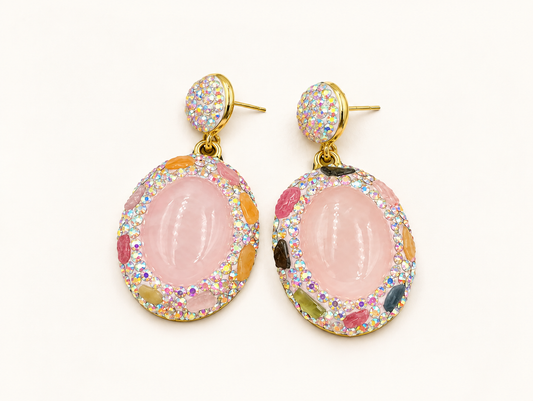 Rose quartz drop earrings with oval pink stones, natural tourmaline accents, Czech crystal borders and gold-tone edges on an off-white background.