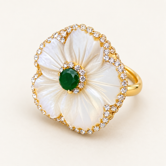 Mother-of-pearl flower ring with carved white petals, a deep green center and a gold-tone setting.