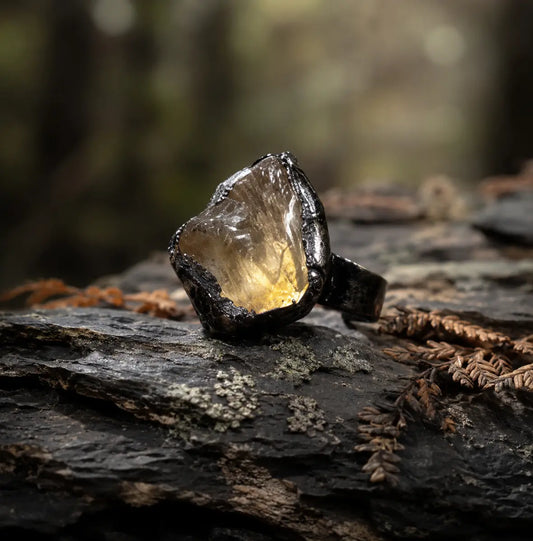 Citrine ring with raw golden-yellow crystal, organic texture, and dark forest-inspired styling.