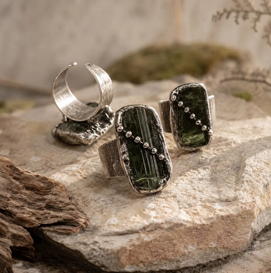 Raw tourmaline ring featuring three natural green stones, open adjustable band, and forest-inspired texture.