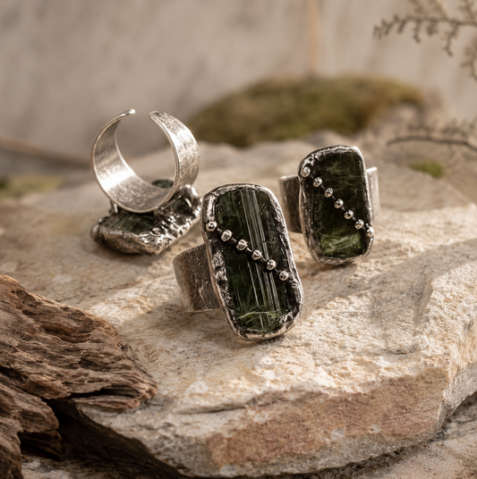 Raw tourmaline ring featuring three natural green stones, open adjustable band, and forest-inspired texture.