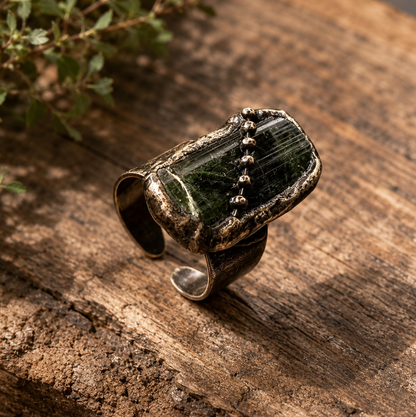 Adjustable gemstone ring with raw green tourmaline stones and an irregular open-band structure.