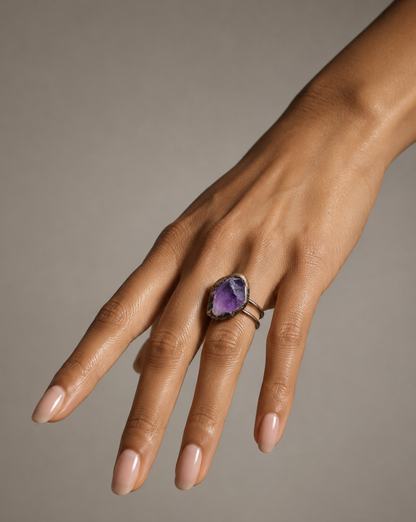 February birthstone ring styled on the hand with deep purple gemstone and quiet evening mood.