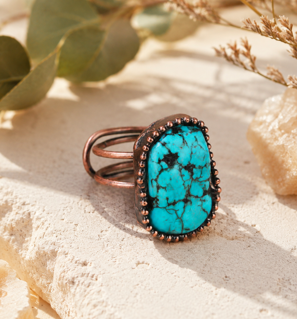 Natural turquoise ring with vivid blue-green stone, dark matrix texture, and sculptural vintage-style setting.
