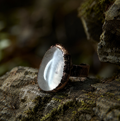 Quartz crystal ring with smooth oval crystal surface, subtle natural texture, and sculptural presence.