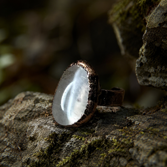 Quartz crystal ring with smooth oval crystal surface, subtle natural texture, and sculptural presence.