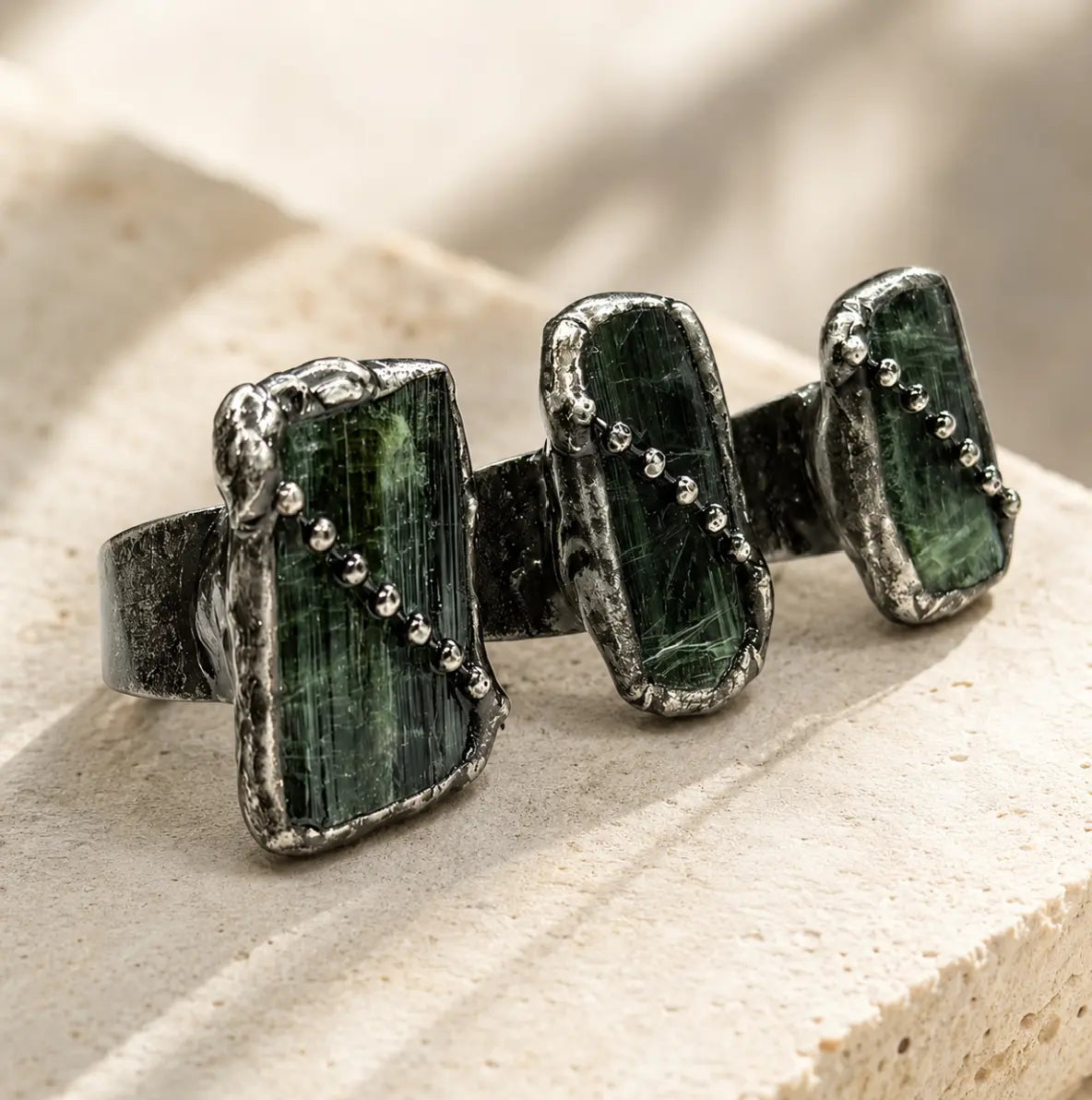 Green tourmaline ring with raw olive stones, vintage-toned setting, and delicate bead-like details.