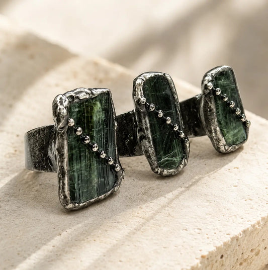 Green tourmaline ring with raw olive stones, vintage-toned setting, and delicate bead-like details.