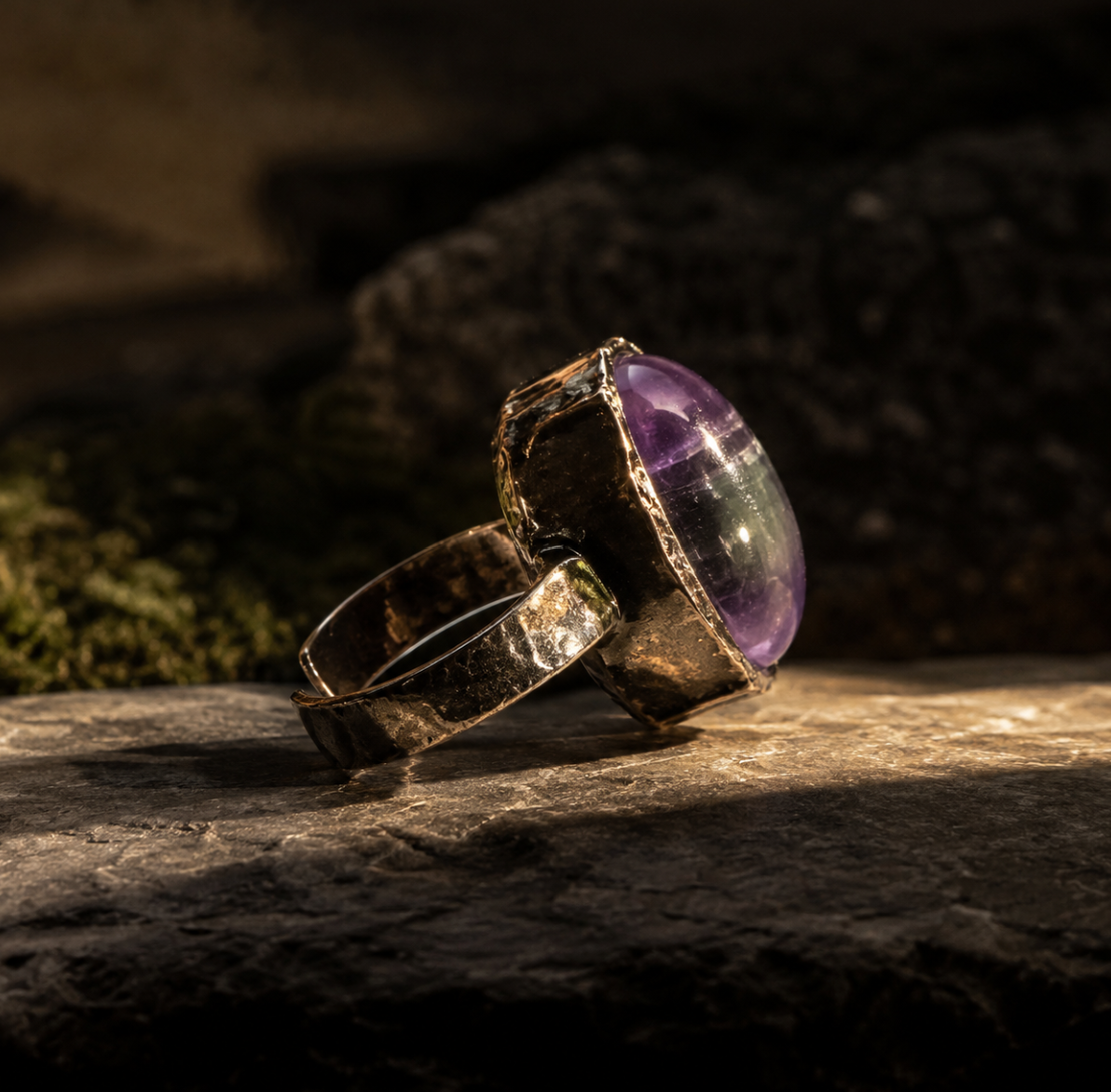 Polished amethyst ring with smooth violet gemstone, organic setting, and quiet forest-inspired mood.