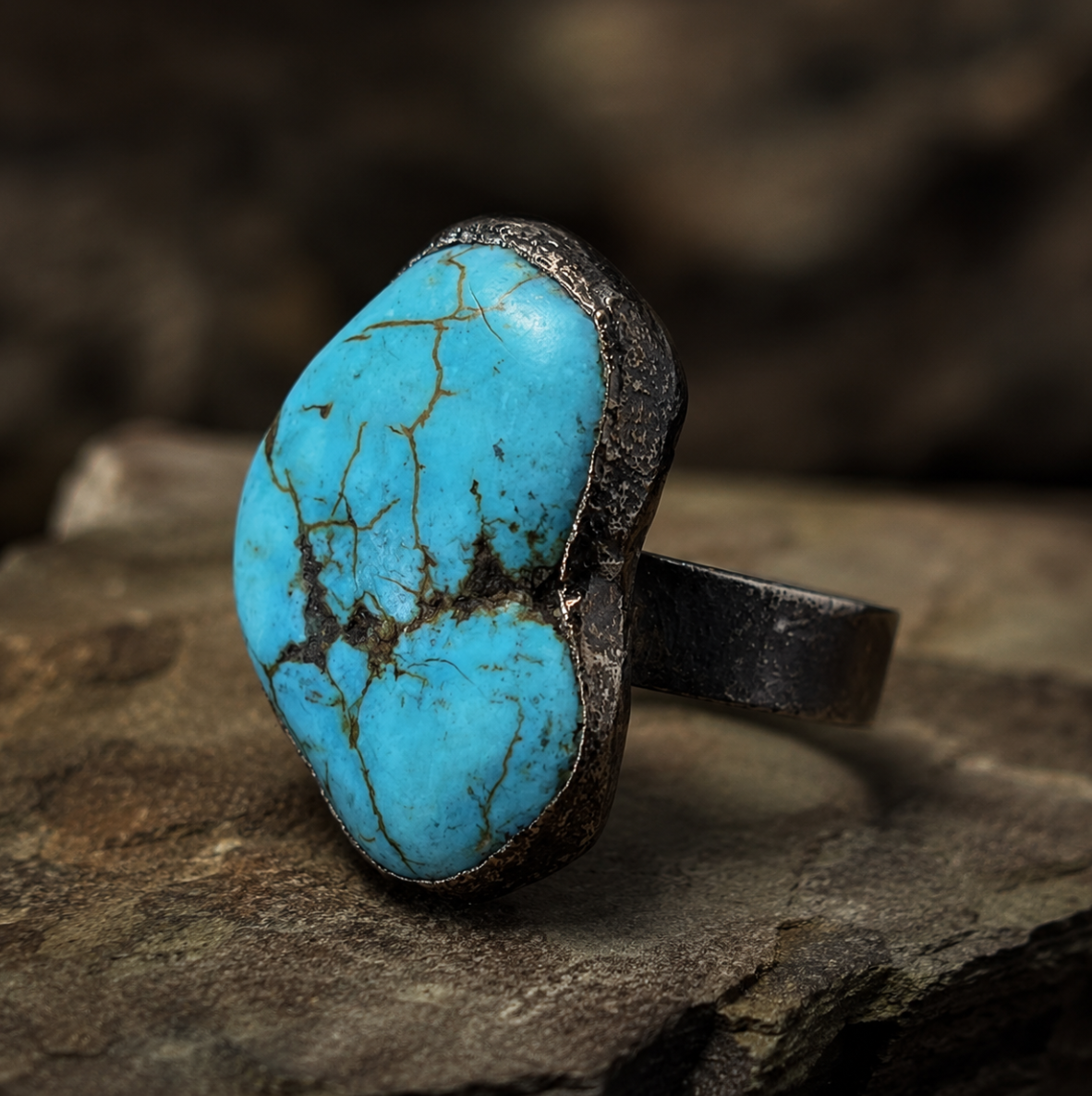 Turquoise ring with vivid blue-green stone, natural matrix pattern, and organic statement shape.