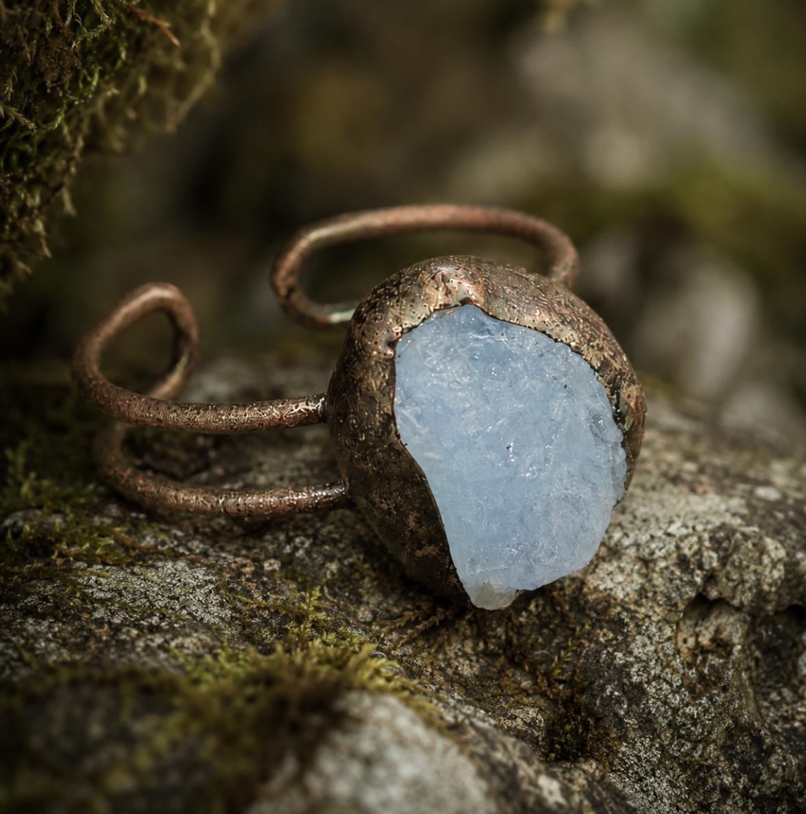 Aquamarine ring with soft ocean-blue stone, natural texture, and organic open-band design.