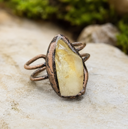 Citrine ring with raw yellow crystal center, organic texture, and earthy sculptural setting.