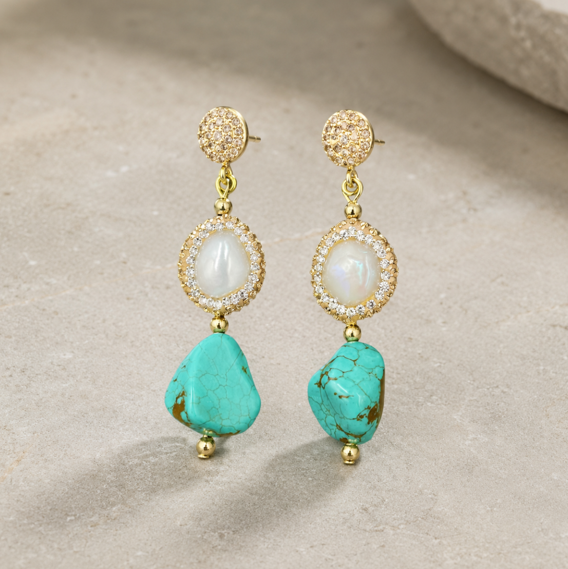 Refined turquoise earrings set with teardrop turquoise stones, pearl accents, and vintage gold details.