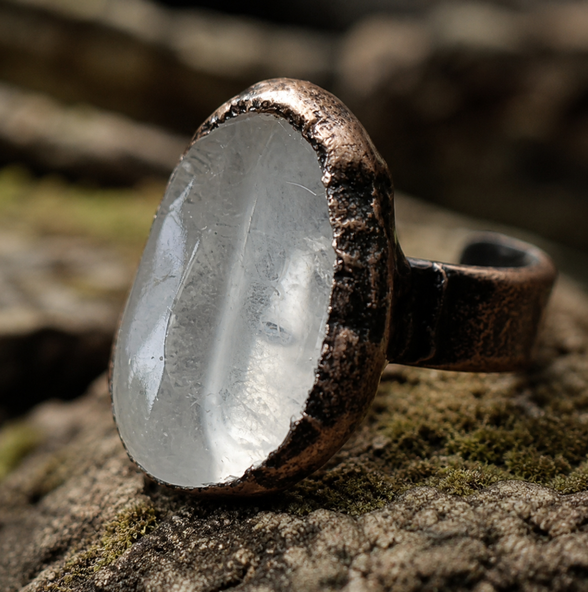 Polished crystal ring displayed in a forest-inspired setting with quiet light and organic character.