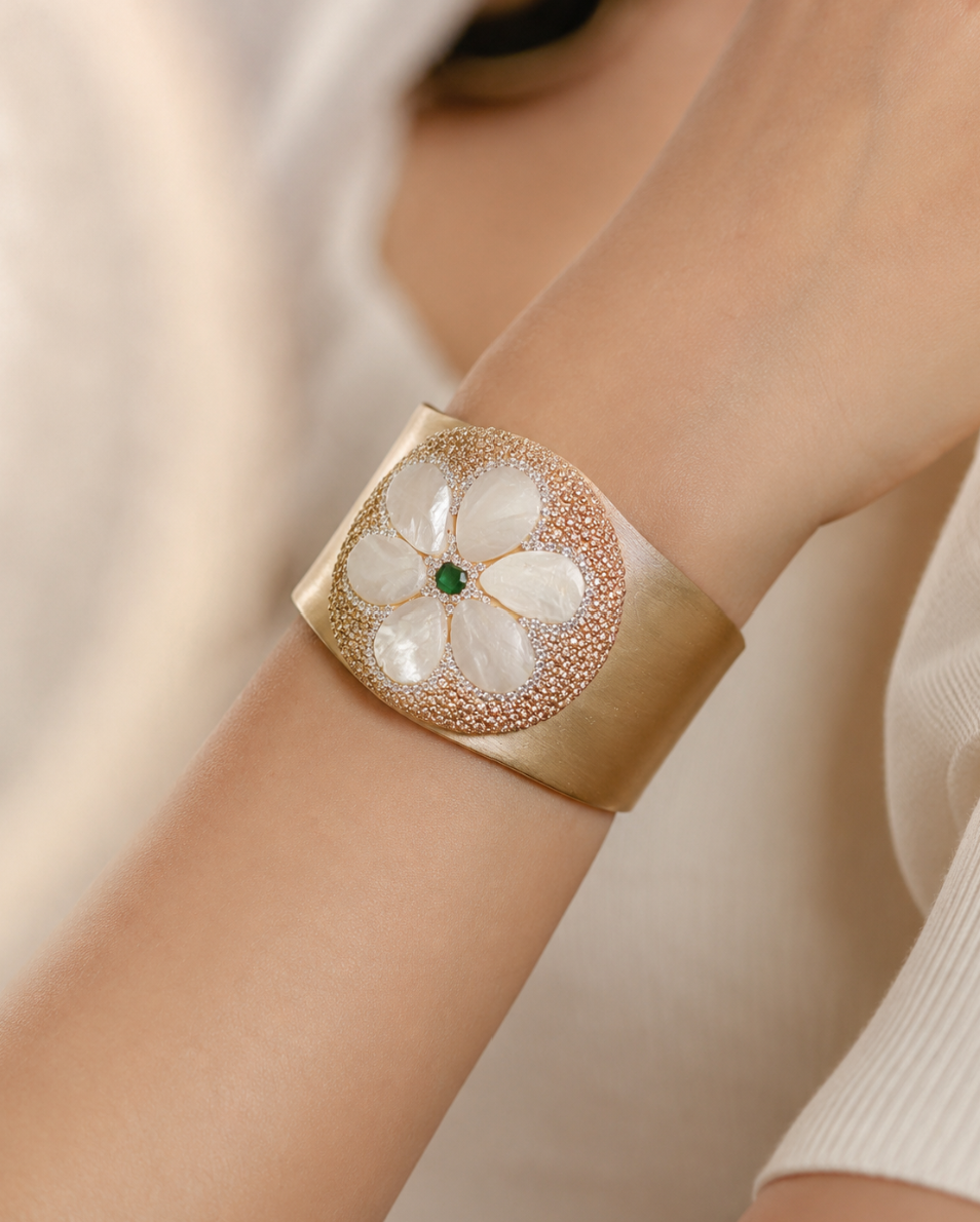 Mother of pearl bracelet with floral shell design, golden cuff texture, and refined feminine elegance.