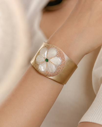 Mother of pearl bracelet with floral shell design, golden cuff texture, and refined feminine elegance.
