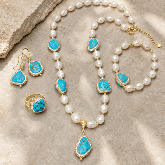 Turquoise jewelry set with baroque pearls, blue-green stones, gold-tone details, necklace, bracelet, earrings, and ring.