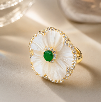Pearl shell ring with mother-of-pearl flower petals, green gemstone center, and gold-tone band.