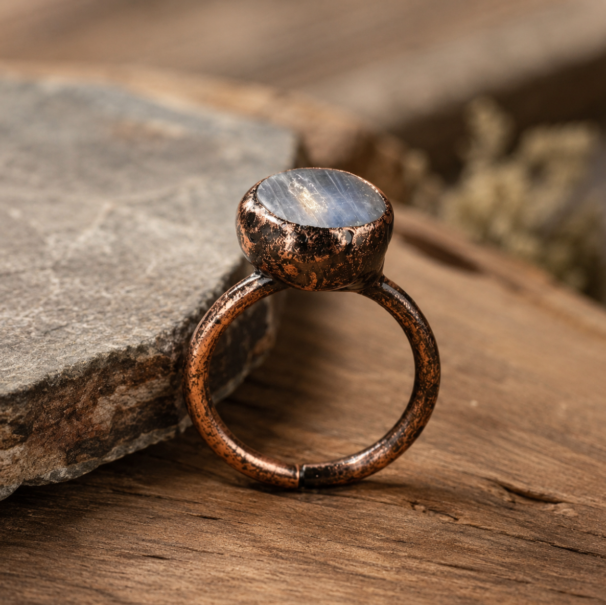Blue kyanite ring with round flat gemstone, rustic metal setting, and soft natural styling.