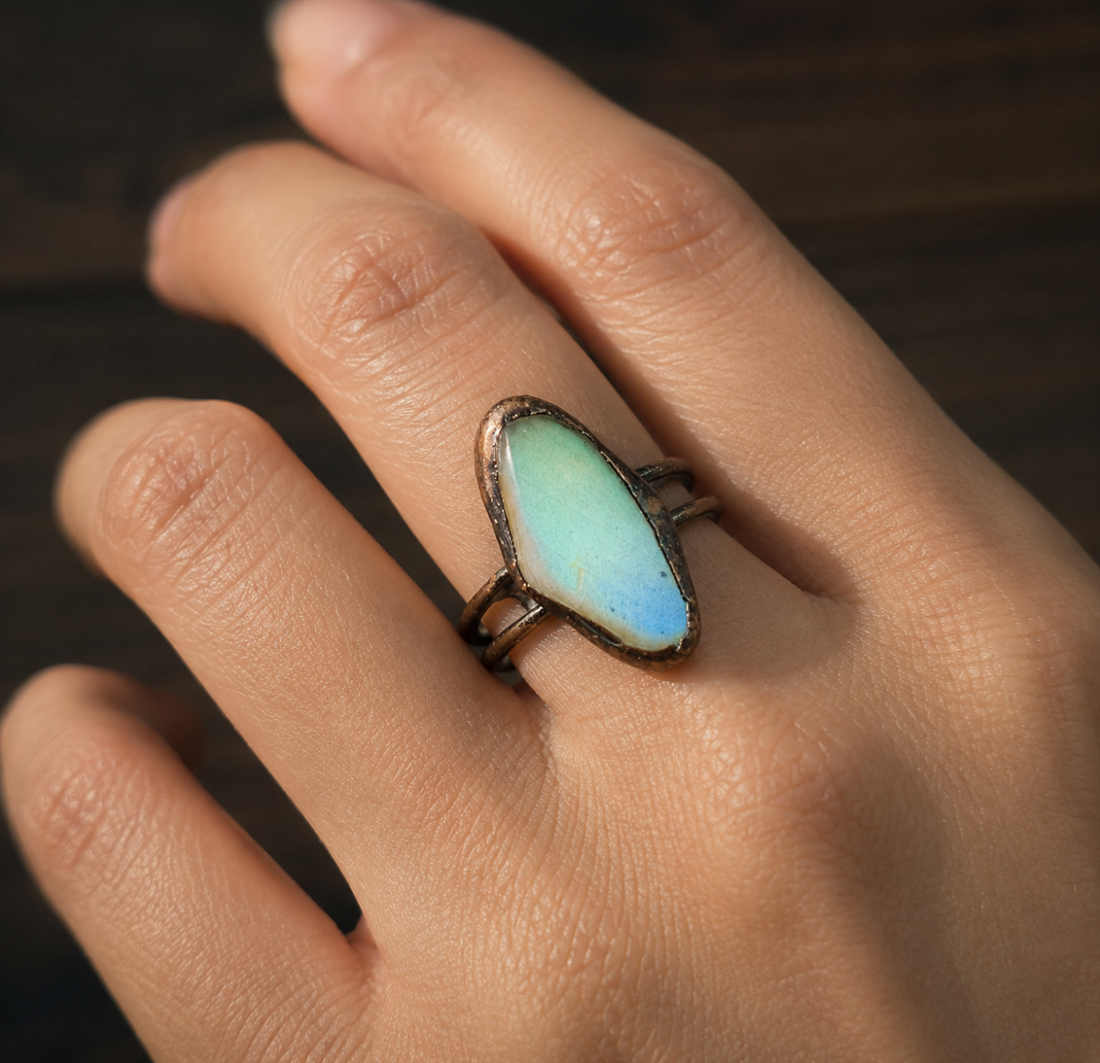 Moonstone ring with soft oval stone, natural glow, and vintage-toned open-band design.