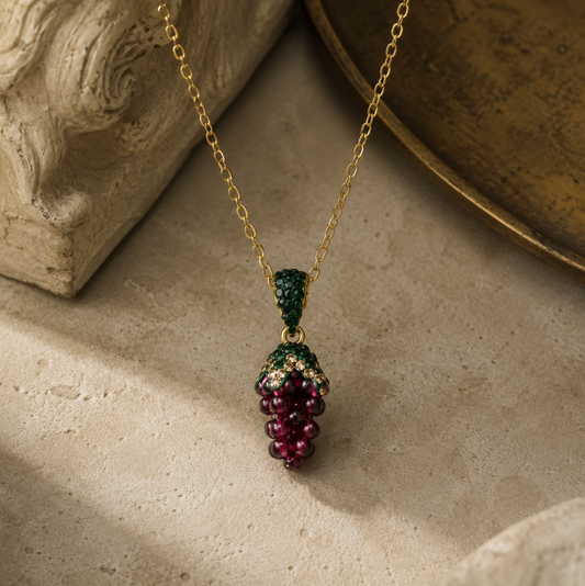 Deep red garnet jewelry pendant resting on soft marble with natural light