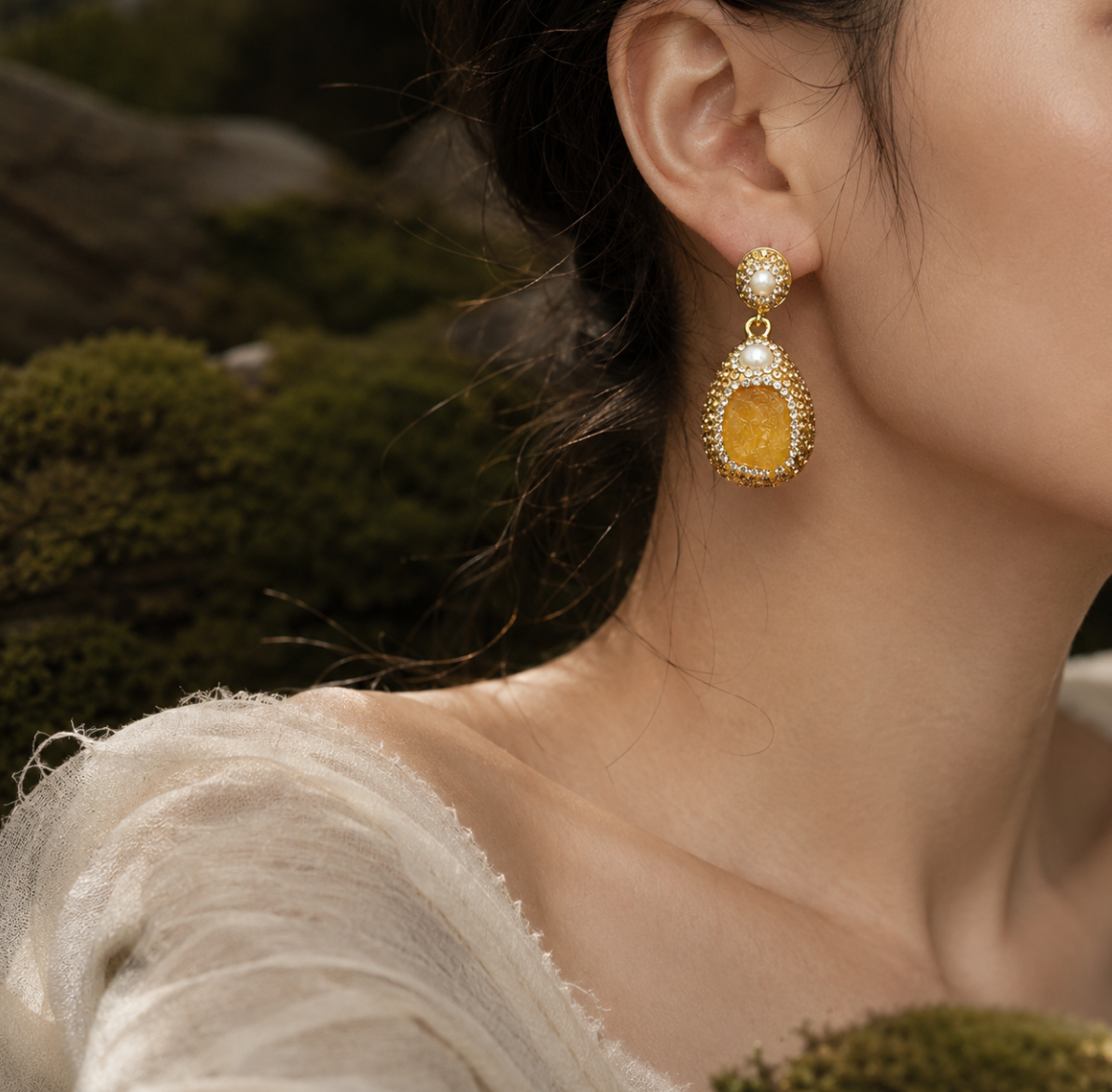Citrine earrings with golden yellow crystal drops, pearl accents, and warm forest light.