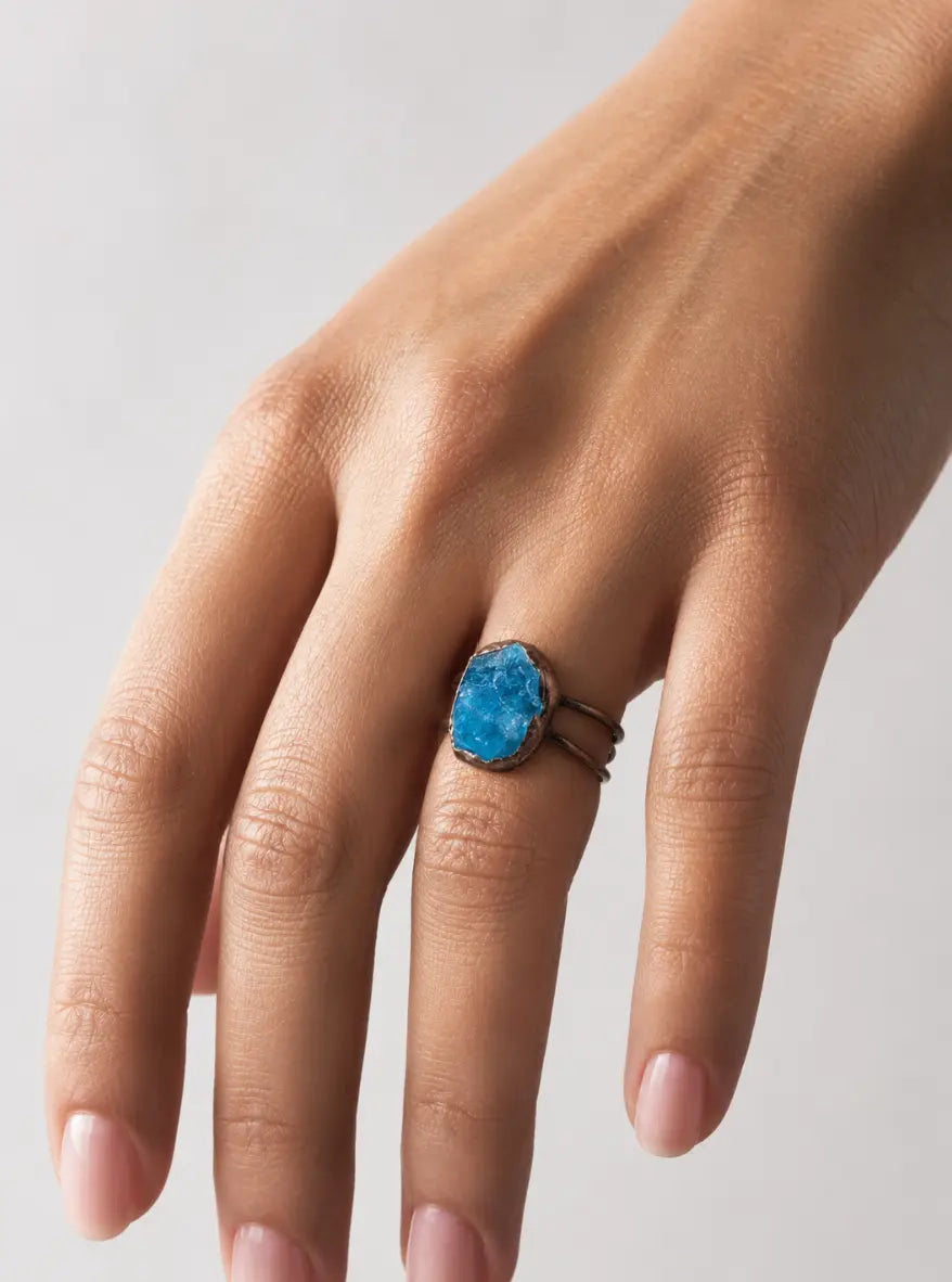 Blue gemstone ring with raw apatite stone, sculptural shape, and calm lake-inspired color.