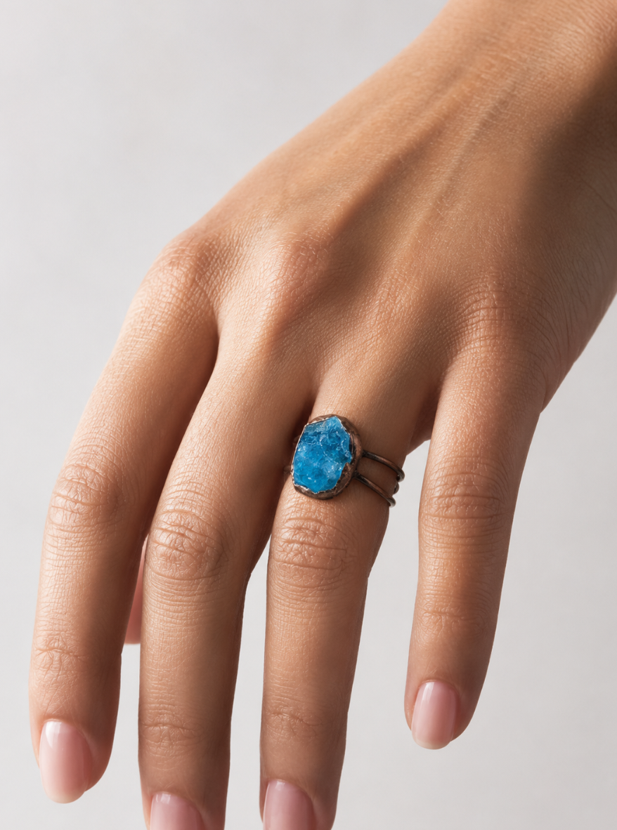Blue gemstone ring with raw apatite stone, sculptural shape, and calm lake-inspired color.