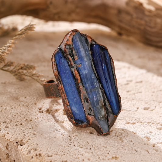 Blue kyanite trio ring with three raw blue stones, organic edges, and a vintage-toned open setting.
