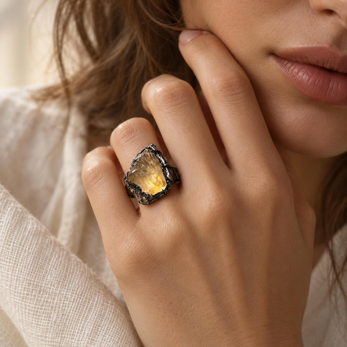 Citrine ring worn near the face, showing the honey-yellow stone at real hand scale and its raised statement profile.