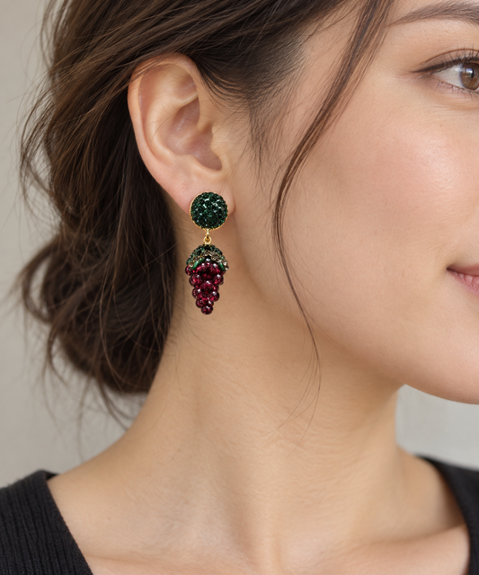 Woman wearing garnet drop earrings, shown beside the ear to reveal the drop length and relative scale.