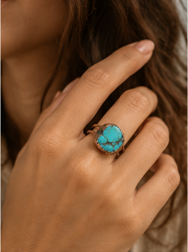 Turquoise ring worn on the hand, showing the real scale of the blue-green stone and double-band design.