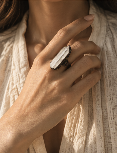 Crystal ring worn on the hand, showing the real scale of the elongated clear quartz point and wide band.