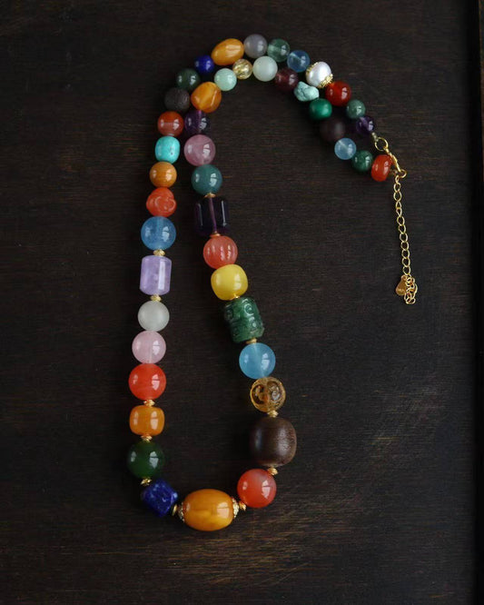 Colorful retro style beaded necklace with various gemstone beads and gold accents. Perfect for retro glamour and complements beaded bracelets.