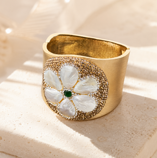 Elegant seashell bracelet displayed on natural stone with shell flower detail and soft luxury styling.