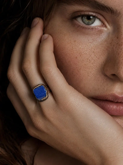 Blue gemstone ring styled on the hand with rich color, soft shadows, and elegant everyday mood.