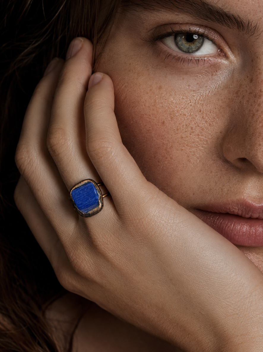 Blue gemstone ring styled on the hand with rich color, soft shadows, and elegant everyday mood.
