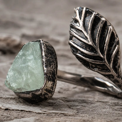 Fluorite feather ring displayed on weathered wood with soft shadows and woodland-inspired styling.